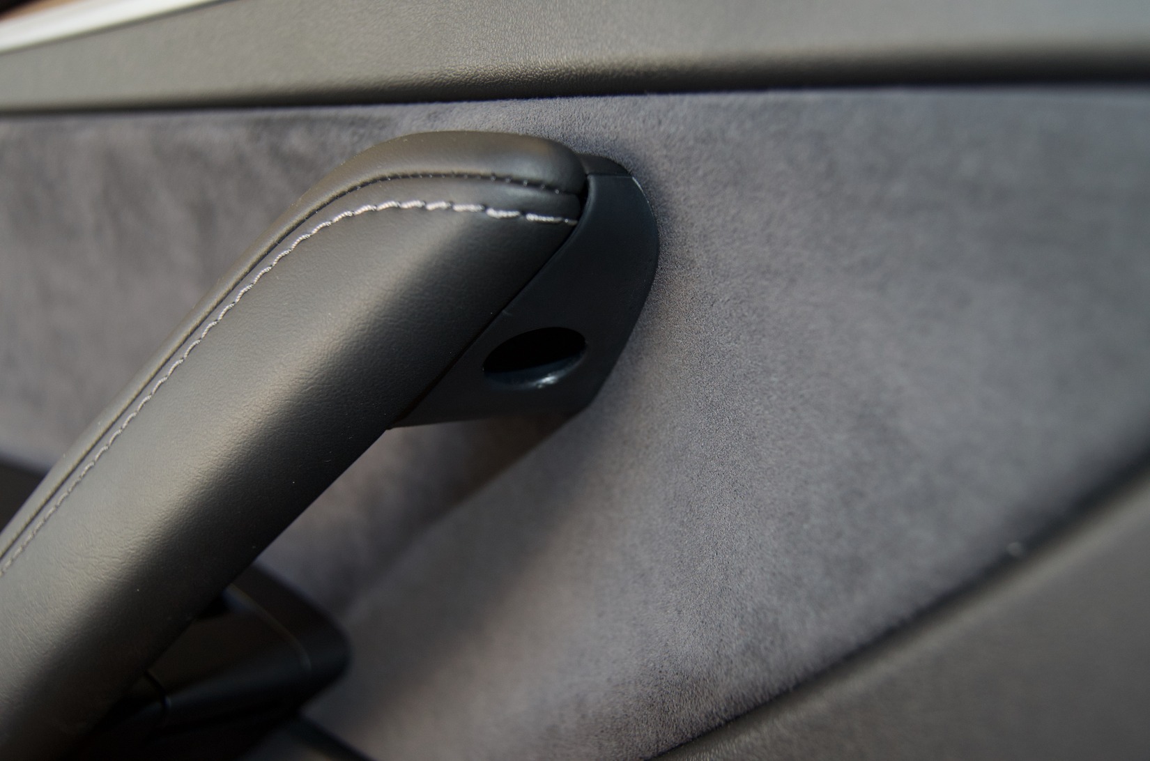 Factory bolt location on the underside of the Tesla Model Y driver door handle